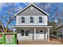 Charming two-story home featuring gray siding, a covered porch, and a white front door at 204 N Yadkin Ave, Spencer, NC 28150