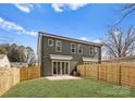 Back exterior view of a newly constructed home with a fenced in yard and sliding glass door at 2221 Edison St, Charlotte, NC 28206