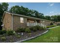 Low angle capturing the front of the home, featuring a charming brick exterior and landscaped garden at 4816 Zion Church Rd, Concord, NC 28025