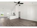 Open-concept living room and kitchen with white walls and wood-look floors at 5177 Flay Rd, Lincolnton, NC 28021