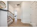 Inviting foyer with hardwood floors, a staircase, and an open view of the well-lit second story at 5373 Orchid Bloom Dr, Indian Land, SC 29707