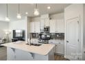 Bright kitchen with modern appliances, quartz countertops, stylish backsplash, and a functional center island at 5373 Orchid Bloom Dr, Indian Land, SC 29707