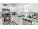 Modern kitchen features white cabinets, granite countertops, stainless steel appliances, and a double sink at 65 Franklin St, Wadesboro, NC 28170