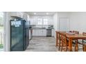 Open kitchen with white cabinetry, a stainless steel refrigerator, and a dining area at 65 Franklin St, Wadesboro, NC 28170