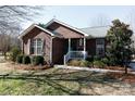 Brick ranch house with landscaped yard and teal front door at 665 Edwards Rd, Fort Lawn, SC 29714