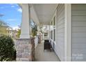 Inviting front porch with stone pillars and comfortable seating at 9635 Andres Duany Dr, Huntersville, NC 28078