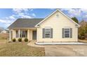 Attractive one-story home with yellow siding, gray shutters, and a manicured front yard at 101 Arbridge Ct, Mount Holly, NC 28120