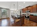 Open kitchen features a center island with bar seating, stainless steel appliances, and hardwood floors at 10120 Garman Hill Dr, Charlotte, NC 28214