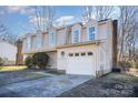 Light brown two-story home with dormer windows and a single car garage at 10718 Downpatrick Pl, Charlotte, NC 28262