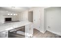 Updated kitchen featuring white cabinets and stainless steel dishwasher, opening to a living area with a fireplace at 10718 Downpatrick Pl, Charlotte, NC 28262