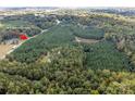 An aerial view of lush, wooded acreage along Mt Holly-Huntersville Rd with a private pond at 11001 Mount Holly Hntrsvlle Rd, Huntersville, NC 28078