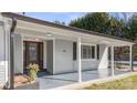 Renovated front porch with gray painted siding and a brown door at 115 E Texas Ave, Bessemer City, NC 28016