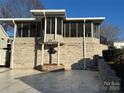 Brick home with a screened porch and a stone planter at 130 Badin Lake Cir, New London, NC 28127