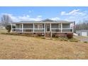 Gray mobile home with wrap-around porch, steps, and American flag at 15918 Big Bear Rd, Albemarle, NC 28001