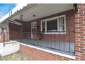 Inviting covered porch with brick accents, black railing, and a cozy bench at 1648 Newton Dr, Statesville, NC 28677