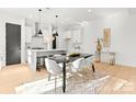 Bright dining room with modern light fixtures and a black dining table at 2149 Highland St, Charlotte, NC 28208