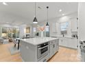 Open-concept kitchen with a large island, modern appliances, and adjacent living and dining areas at 2149 Highland St, Charlotte, NC 28208