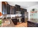 Modern kitchen featuring stainless steel appliances, granite countertops, and dark wood cabinets at 2727 Cypress Oak Ln, Gastonia, NC 28056