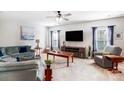 Bright living room featuring plush seating, a ceiling fan, and large windows with blue curtains at 2727 Cypress Oak Ln, Gastonia, NC 28056