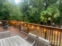 Outdoor deck area featuring wood railings and string lights, perfect for entertaining guests or enjoying the peaceful wooded view at 3995 Burton Ln, Denver, NC 28037