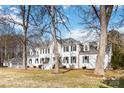 Stately white brick home featuring mature trees and a well-manicured lawn at 4001 Carmel Acres Dr, Charlotte, NC 28226