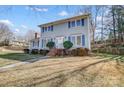 Two-story home featuring blue shutters, brick chimney and entrance, and well-maintained landscaping at 7707 Ritter Dr, Charlotte, NC 28270