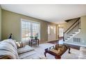 Inviting living room featuring large windows, a staircase, and hardwood floors at 7707 Ritter Dr, Charlotte, NC 28270