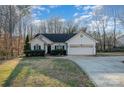 Charming single-story home with well-manicured lawn, mature trees, and attached two-car garage at 781 Woodlawn Ave, Mount Holly, NC 28120