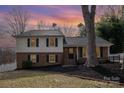 Charming two-story home featuring a brick facade, complemented by green shutters and mature trees at 8025 Cliffside Dr, Charlotte, NC 28270