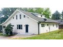 Angle view of white home with multiple windows and a gray roof, complemented by lush green grass at 105 N Inman Ave, Bessemer City, NC 28016