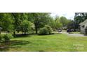 Expansive front yard with lush green lawn and mature trees, creating a serene and inviting outdoor space at 105 N Inman Ave, Bessemer City, NC 28016
