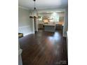 An open-concept kitchen featuring a large island, updated appliances, tile backsplash, and a decorative chandelier at 105 N Inman Ave, Bessemer City, NC 28016