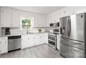 Bright kitchen featuring stainless steel appliances, gray counters, and ample white cabinetry at 107 Deese Ct, Indian Trail, NC 28079