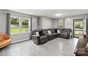 Spacious living room featuring gray luxury vinyl flooring, neutral walls, and large windows at 107 Deese Ct, Indian Trail, NC 28079