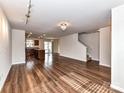 Open-concept living space featuring wood floors and a view of the kitchen at 1128 Tangle Ridge Se Dr, Concord, NC 28025