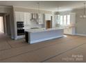 Modern kitchen with stainless steel appliances, island, and pendant lighting at 13708 Tranquil Day Dr, Matthews, NC 28105