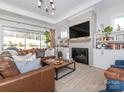 Spacious living room with a fireplace, built-in shelving, and large windows at 14543 Crosswater Ln, Charlotte, NC 28278