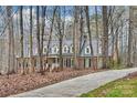 Lovely home with a long driveway surrounded by tall trees, and a brick exterior with black shutters at 2305 Beechwood Dr, Waxhaw, NC 28173
