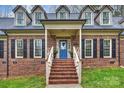 Charming brick home entrance with a blue front door, brick steps, and white railings at 2305 Beechwood Dr, Waxhaw, NC 28173