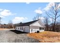 Exterior view of the home with a gravel driveway and easy access to the garage at 3409 Dallas High Shoals Hwy, Dallas, NC 28034