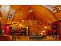 Living room features wood vaulted ceilings and exposed beams, seamlessly connected to the kitchen at 3804 Putters Ln, Maiden, NC 28650