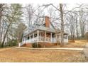 Charming blue home with a brick foundation and wraparound porch surrounded by mature trees at 622 Oakdale Dr, Statesville, NC 28677