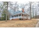 Charming blue home with a brick foundation and wraparound porch surrounded by mature trees at 622 Oakdale Dr, Statesville, NC 28677