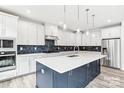 Modern kitchen featuring white cabinets, a large island, and dark blue accents at 7120 Wayfarer Dr # 0079, Charlotte, NC 28269