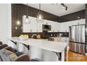 Kitchen with modern stainless steel appliances, subway tile backsplash, quartz countertops, and bar seating at 971 Westmere Ave, Charlotte, NC 28208