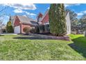 A portion of a well-maintained lawn, lush landscaping, and brick home's side at 1027 Fountainbrook Dr, Indian Trail, NC 28079