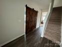 Spacious entryway with dark hardwood floors, a barn door, and carpeted stairs at 1112 Culver Spring Way, Charlotte, NC 28215