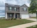 Two-story house with gray siding, solar panels, and a white garage door at 1112 Culver Spring Way, Charlotte, NC 28215