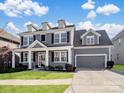 Gray two-story house with a two-car garage and landscaped lawn at 11317 Trailside Nw Rd, Huntersville, NC 28078