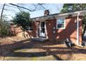 Brick home side view with a small patio and landscaping at 1138 Norland Rd, Charlotte, NC 28205